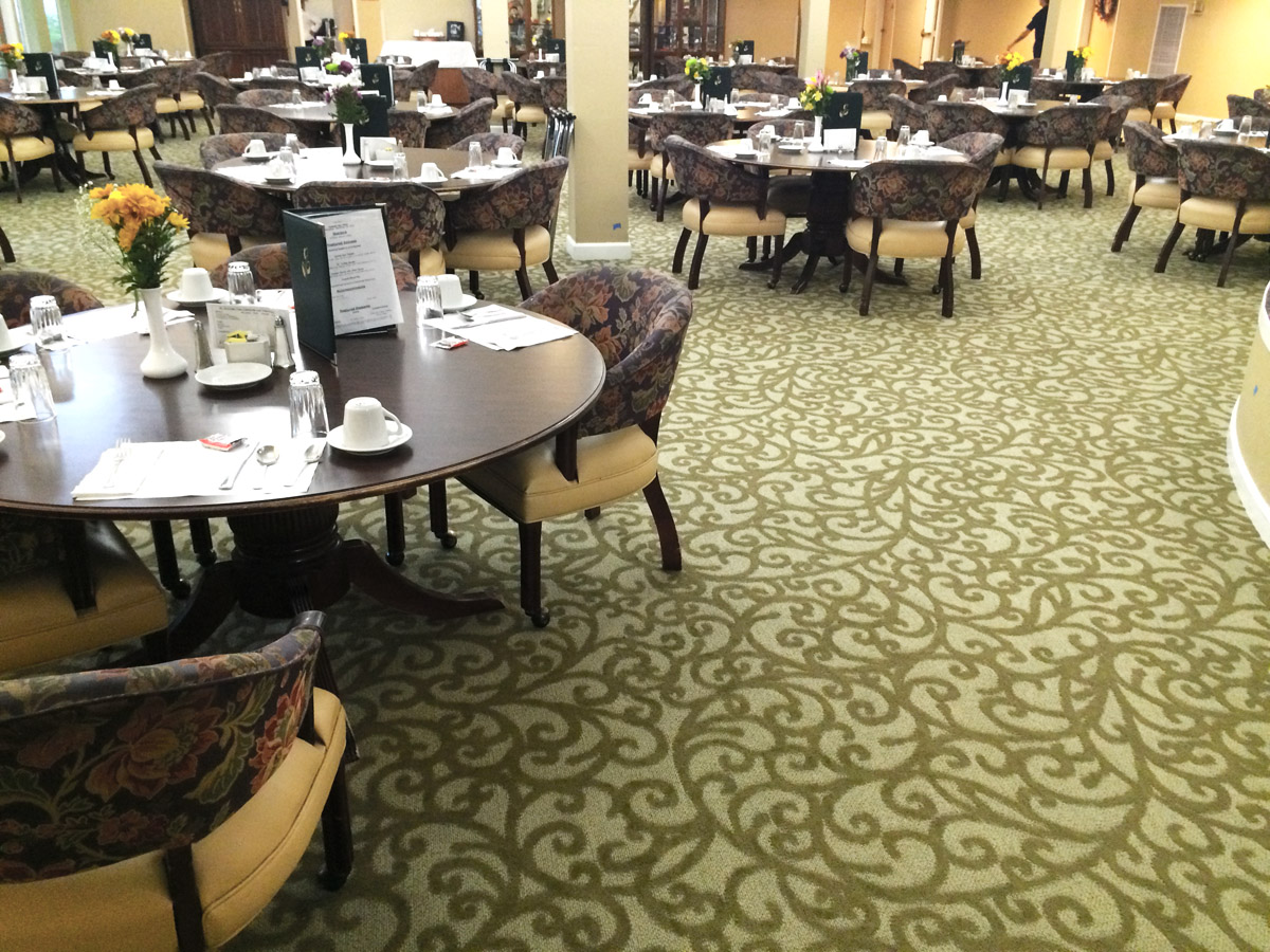 Assisted Living Dining room with patterned carpet.